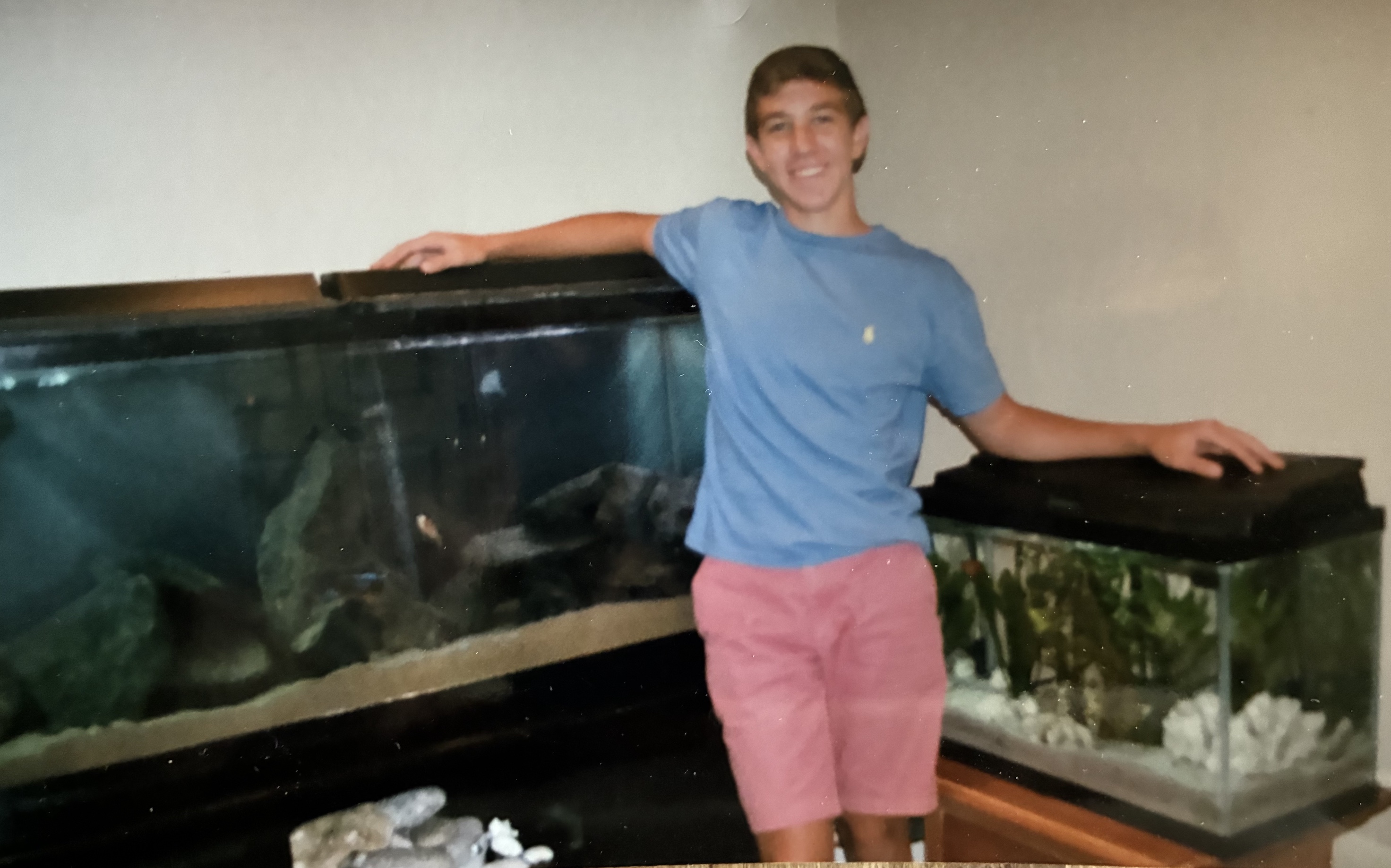 Parker standing between two large home aquariums